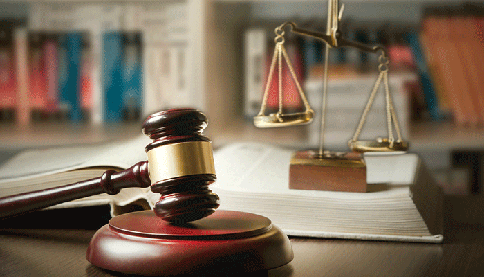 Se visualiza una balanza que representa la Justicia y un mazo utilizado por un juez